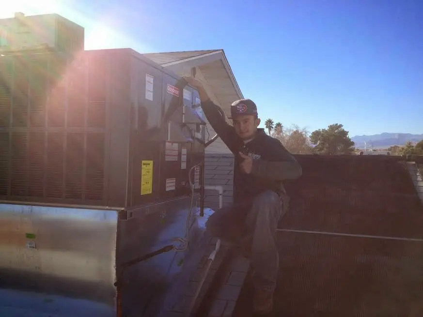 HVAC technician performing HVAC Inspection on a rooftop unit in Colleyville